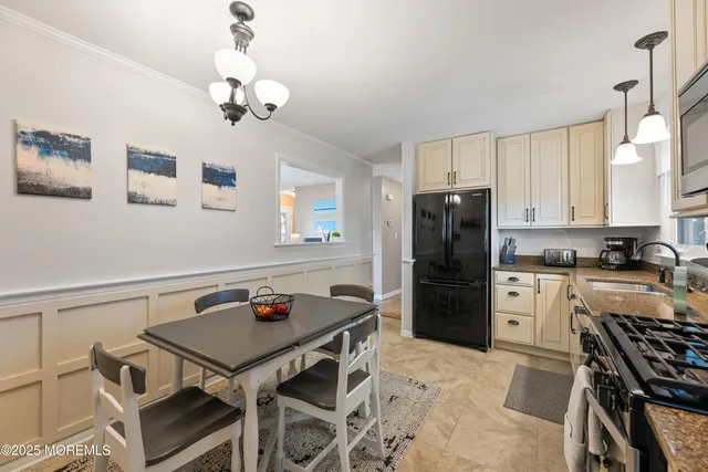 a kitchen with a refrigerator a stove a dining table and chairs