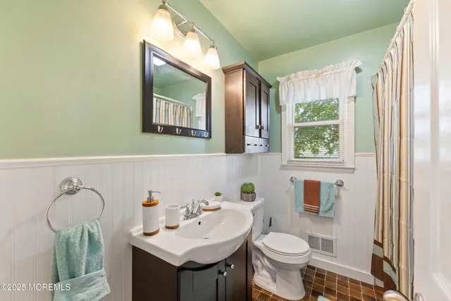 a bathroom with a sink toilet and mirror