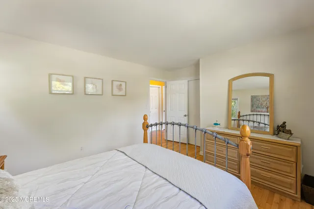 a bedroom with a bed a mirror and furniture