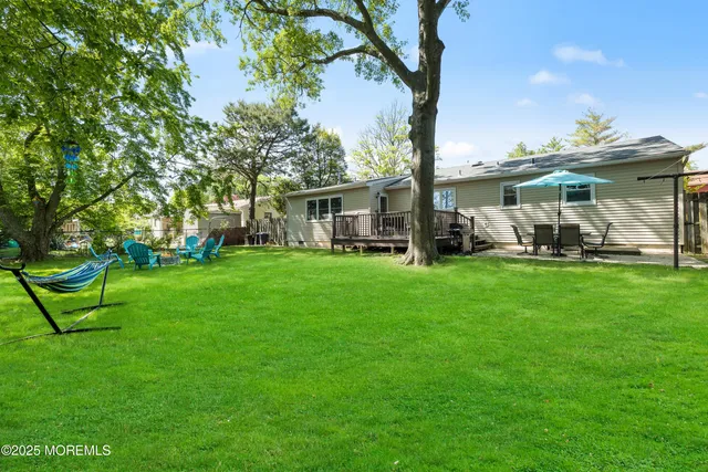 a view of a house with a big yard and sitting area
