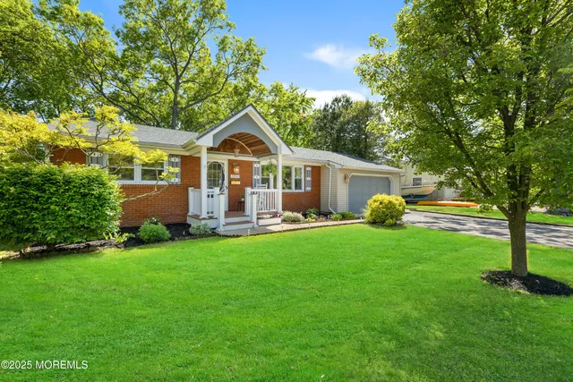 a front view of a house with yard and green space