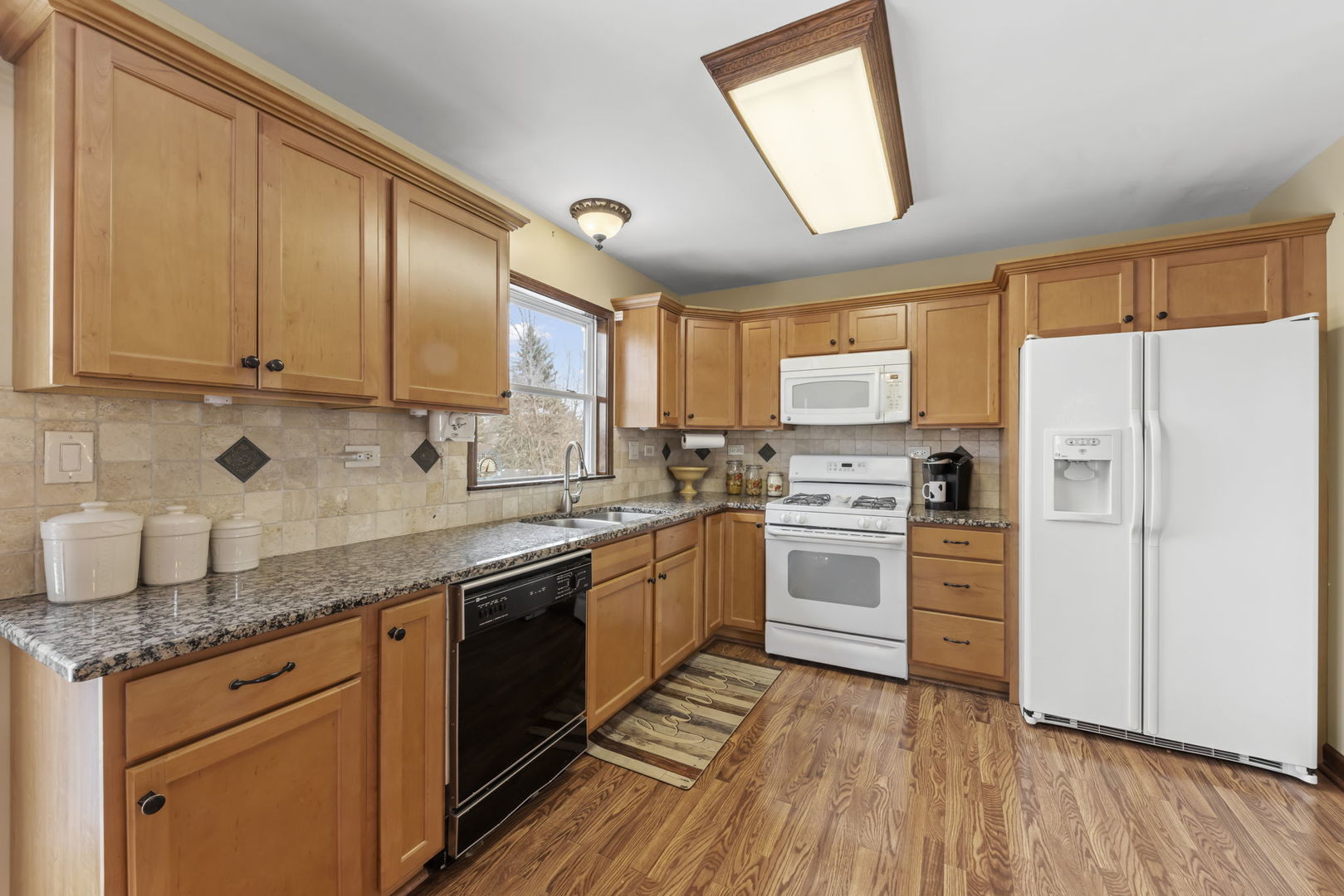 580 Whitehall Way Bolingbrook, IL 60440 - Photo 11 of 25 a kitchen with granite countertop stainless steel appliances a refrigerator cabinets and wooden floor