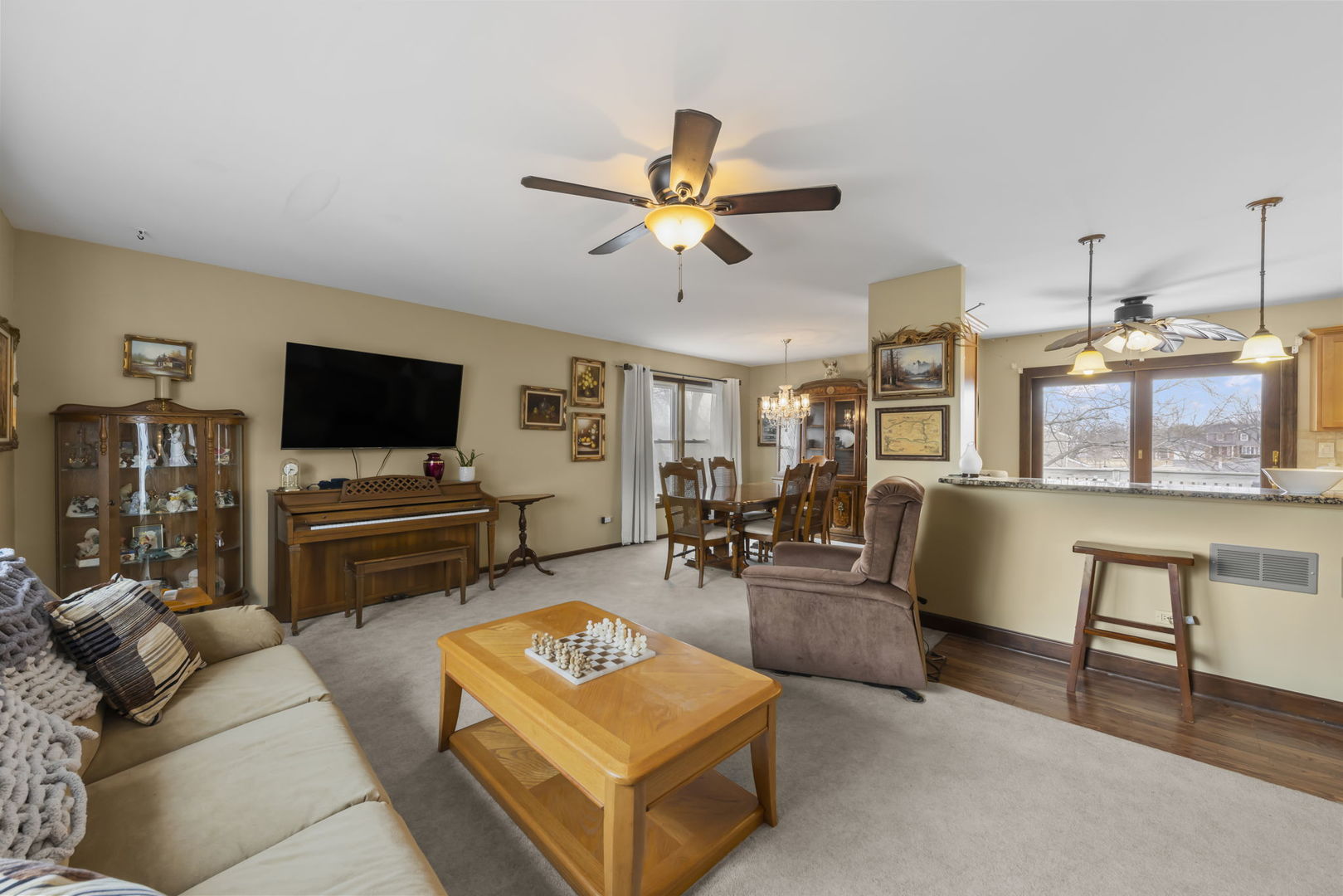 580 Whitehall Way Bolingbrook, IL 60440 - Photo 4 of 25 a living room with furniture and a flat screen tv with kitchen view