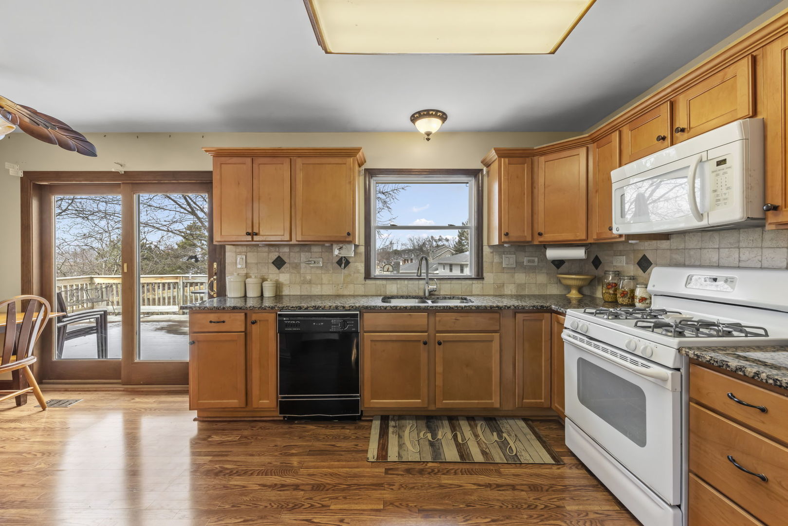 580 Whitehall Way Bolingbrook, IL 60440 - Photo 10 of 25 a kitchen with stainless steel appliances granite countertop a stove top oven a sink dishwasher a dining table and chairs with wooden floor