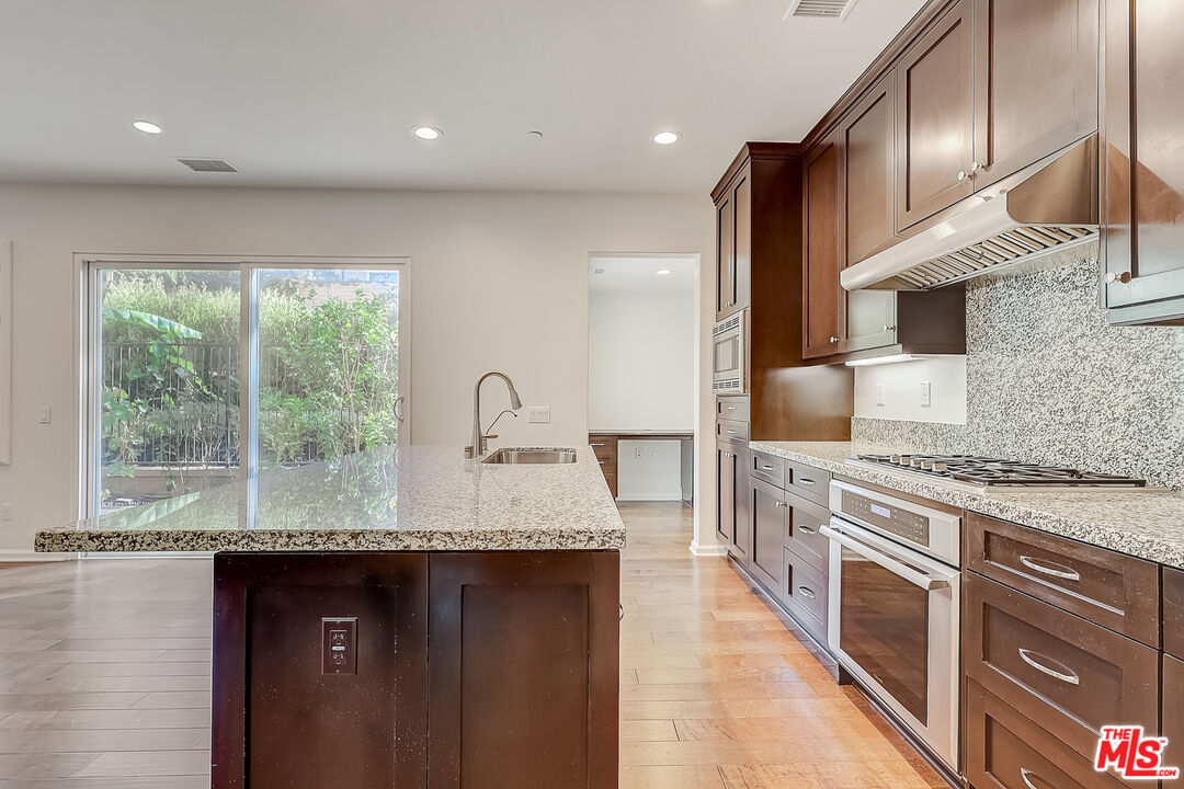 130 Firefly Irvine, CA 92618 - Photo 12 of 29 a kitchen with stainless steel appliances granite countertop a stove a sink and a wooden cabinets