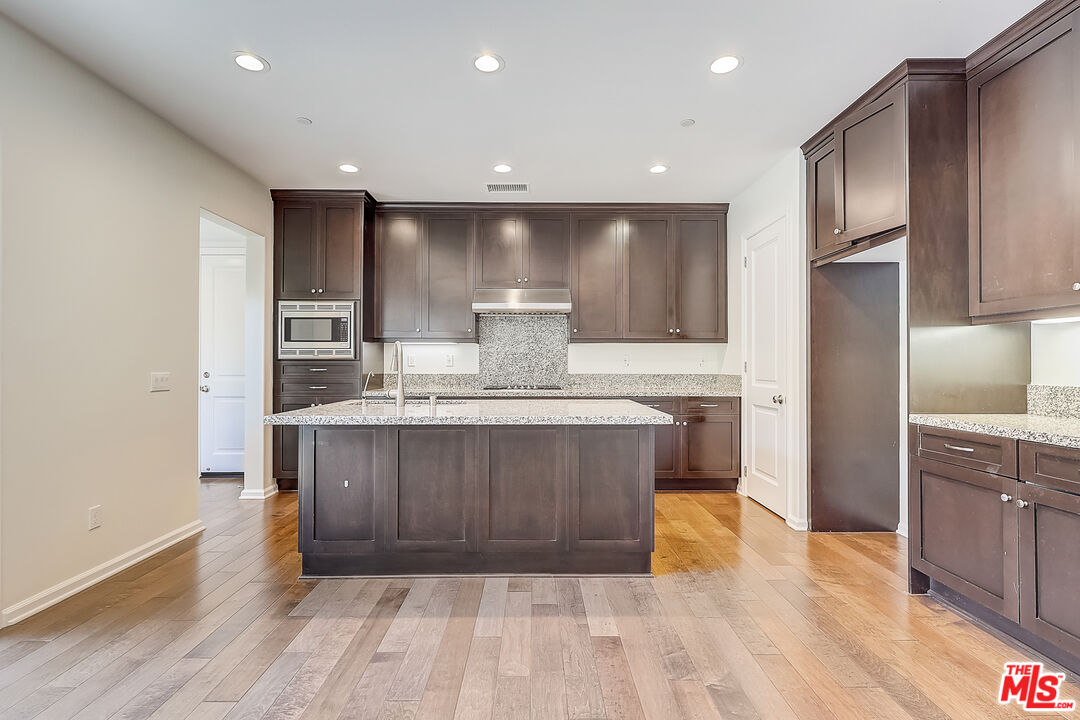 130 Firefly Irvine, CA 92618 - Photo 10 of 29 a kitchen with kitchen island granite countertop wooden cabinets and a sink
