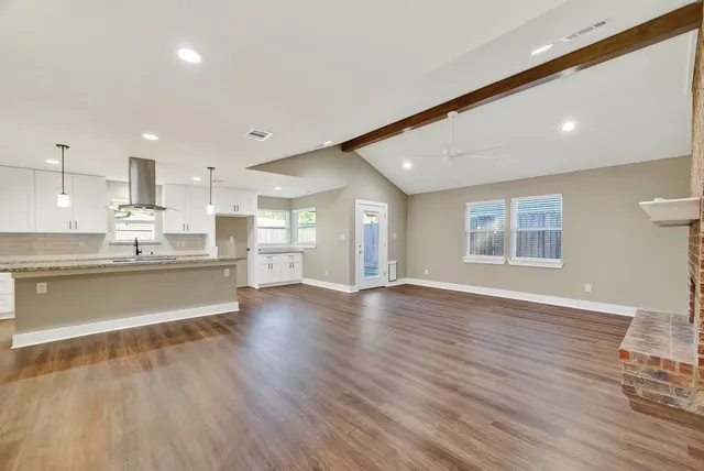 a large kitchen with large windows and wooden floor