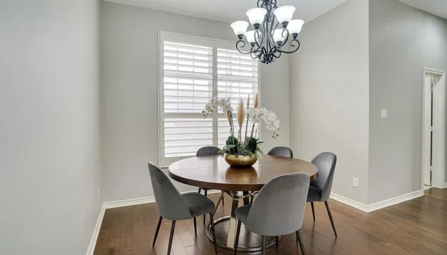 a dining room with furniture a chandelier and wooden floor