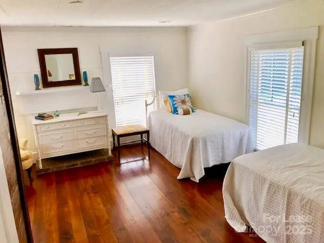 a bedroom with two beds and wooden floor