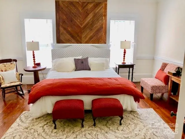 a bedroom with two beds and painting on wall