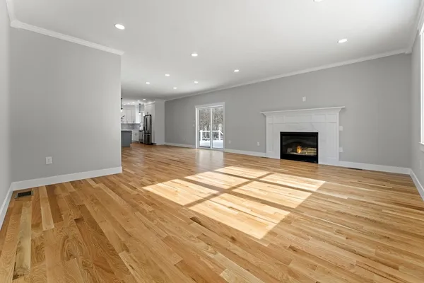 a view of empty room with wooden floor and fireplace