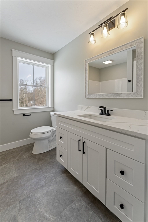 29 Thornton Street Mendon, MA 01756 - Photo 32 of 42 a bathroom with a double vanity sink a toilet and a window