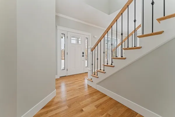a view of staircase with wooden floor and white walls