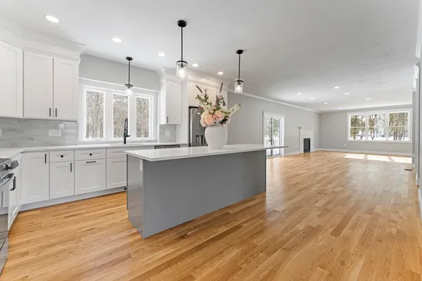 a large kitchen with granite countertop a large counter top a sink stainless steel appliances and cabinets