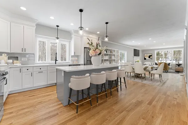 a large kitchen with lots of counter space and dining table chairs