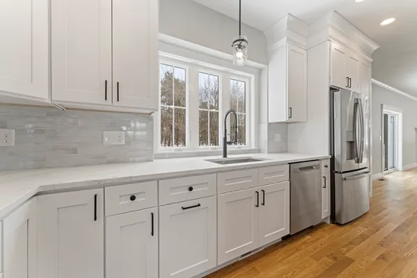 a kitchen with white cabinets and refrigerator