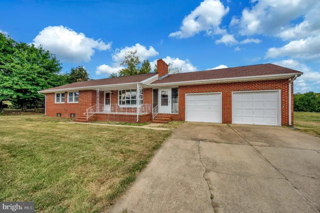 a front view of a house with a garden and yard