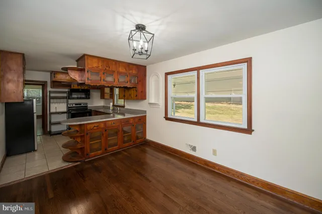 a kitchen view with wooden floor and a window
