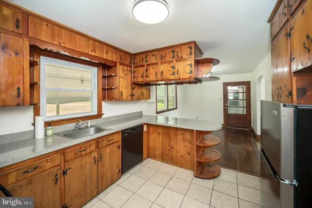 a kitchen with a sink refrigerator and cabinets