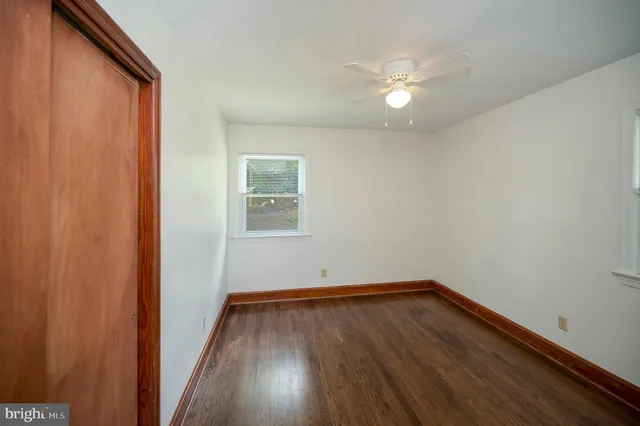 a view of a room with wooden floor and fan