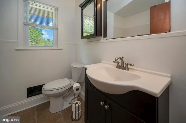 a bathroom with a sink toilet and a window