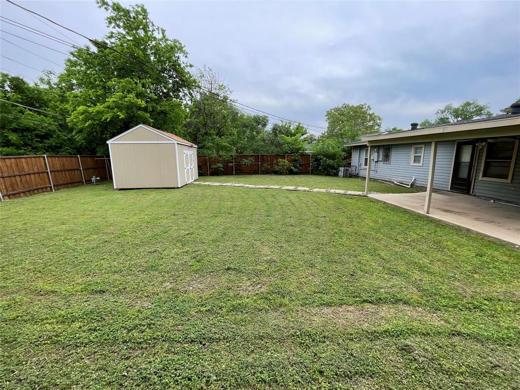 2827 Modree Avenue Dallas, TX 75216 - Photo 3 of 4 Fenced backyard featuring a storage unit and a patio area