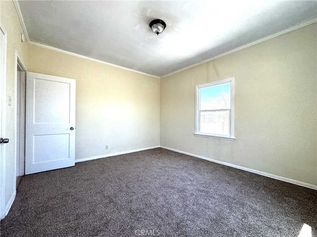 13407 Holly Street Trona, CA 93562 - Photo 13 of 25 Bedroom
Bright and spacious bedroom with fresh paint and brand-new carpet, ready for move-in. Large window lets in plenty of natural light and provides a view of the property. Neutral tones make it easy to style as a primary, guest room, or office. Clean lines and simple finishes create a fresh, welcoming atmosphere.