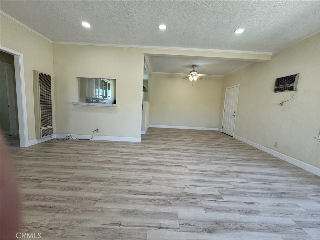 13407 Holly Street Trona, CA 93562 - Photo 18 of 25 Living & Dining Area – 13407 Holly
Expansive open living and dining space with fresh wood-look flooring and neutral paint.
Recessed lighting and ceiling fan provide both modern style and comfort.
Large picture windows brighten the room with natural light.
Convenient kitchen pass-through window creates easy flow for serving and entertaining.
Flexible layout allows room for both a formal dining table and casual living area.