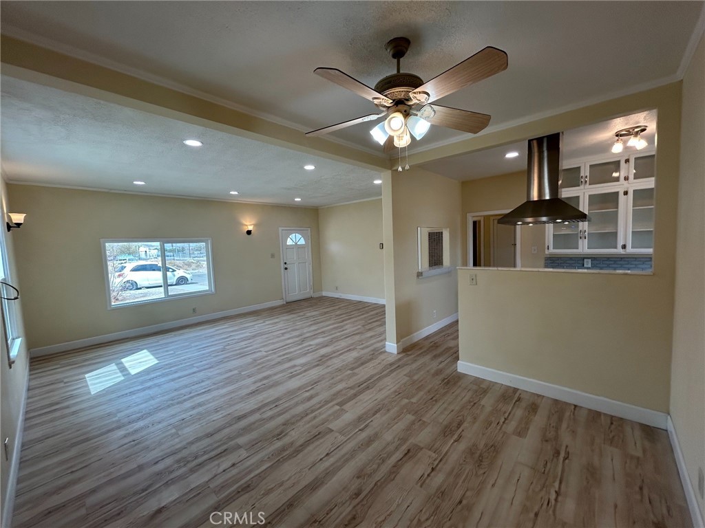 13407 Holly Street Trona, CA 93562 - Photo 4 of 25 Overall Flow
Open-concept design ties the living, dining, and kitchen areas seamlessly together.
Fresh flooring runs throughout the main living areas, creating a cohesive look.
Ceiling fans and updated lighting balance style with everyday comfort.