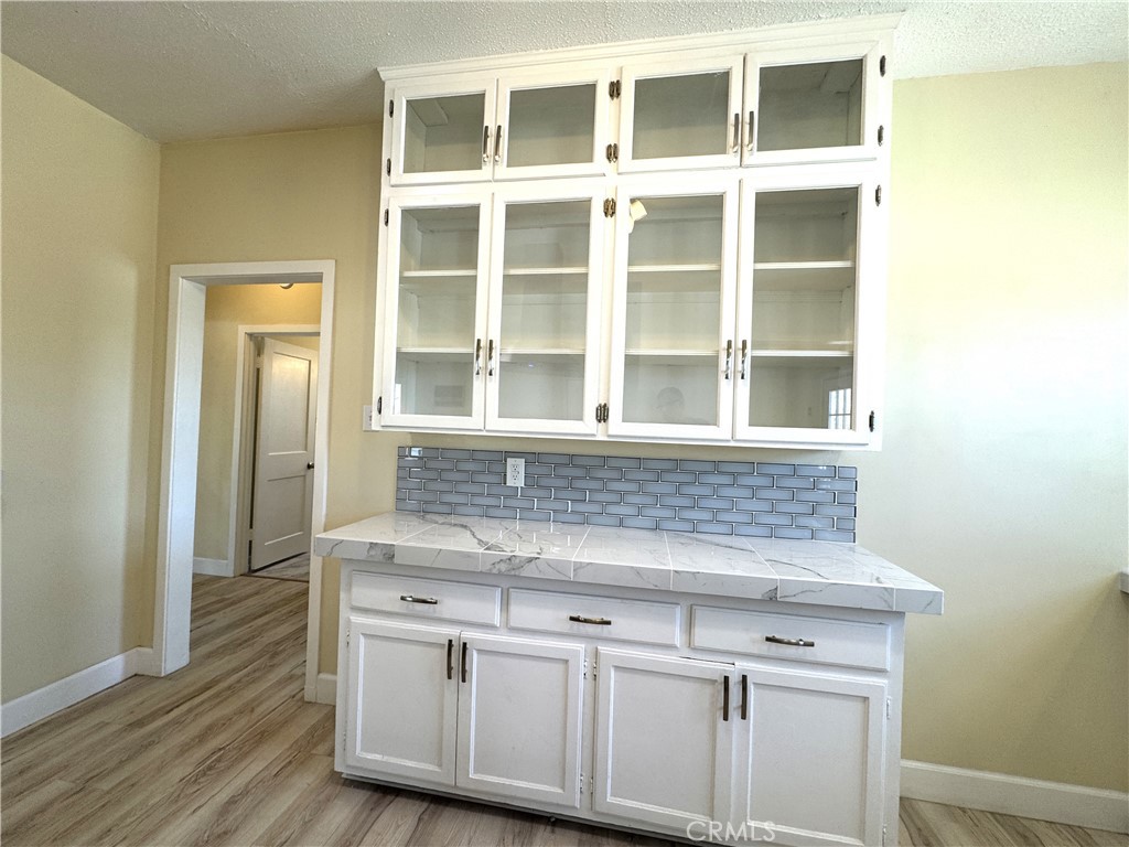 13407 Holly Street Trona, CA 93562 - Photo 9 of 25 Built-in Cabinetry
Charming built-in hutch with glass-front cabinets offers both storage and display space. Subway tile backsplash and marble-look counter add a touch of elegance. Perfect for extra kitchen storage, a coffee bar, or showcasing décor.