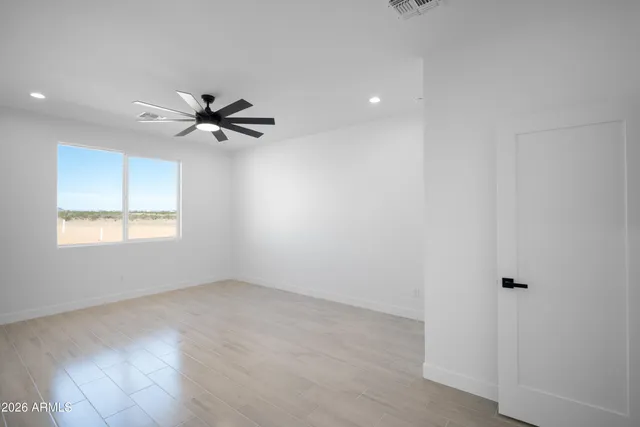 an empty room with a window and a fan