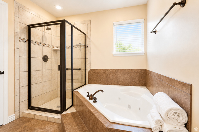 896 Cres Drive South Mapleton, UT 84664 - Photo 17 of 32 Corner jetted soaking tub with bronze-finish fixtures, complemented by a separate glass-enclosed shower featuring tile surround and a decorative accent band