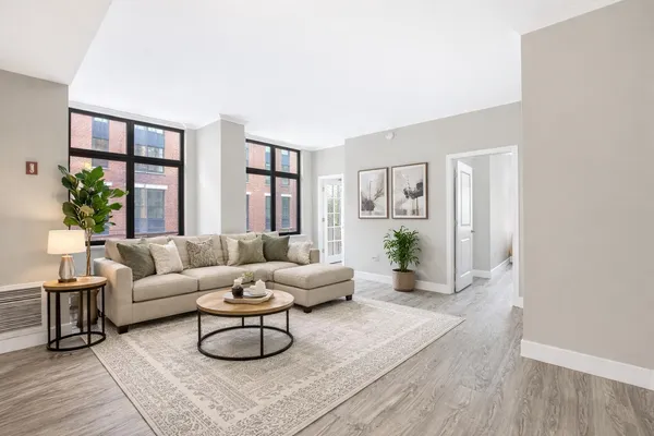 a living room with furniture potted plant and a large window