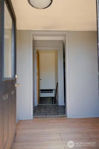 a view of a hallway with wooden floor and a cabinet