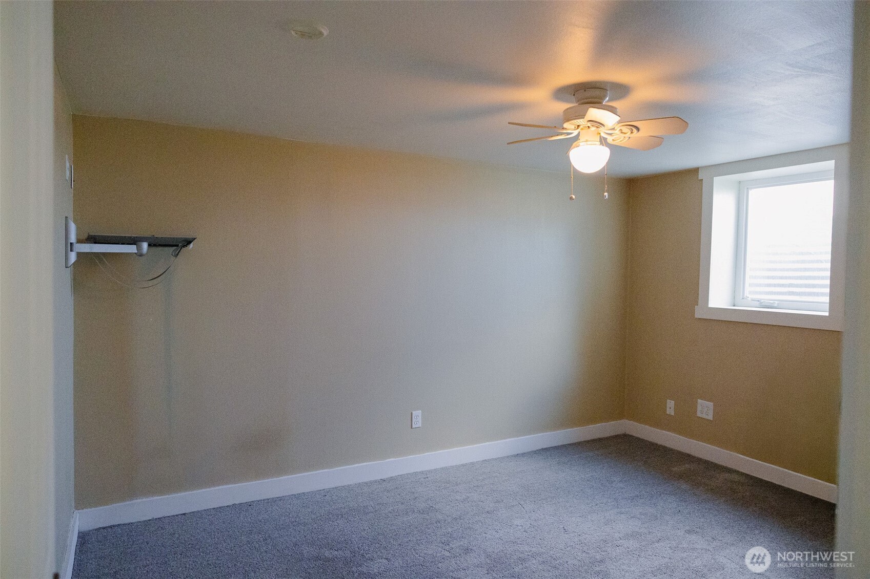 12 A Temby Road Tonasket, WA 98855 - Photo 25 of 36 an empty room with a chandelier fan and a window