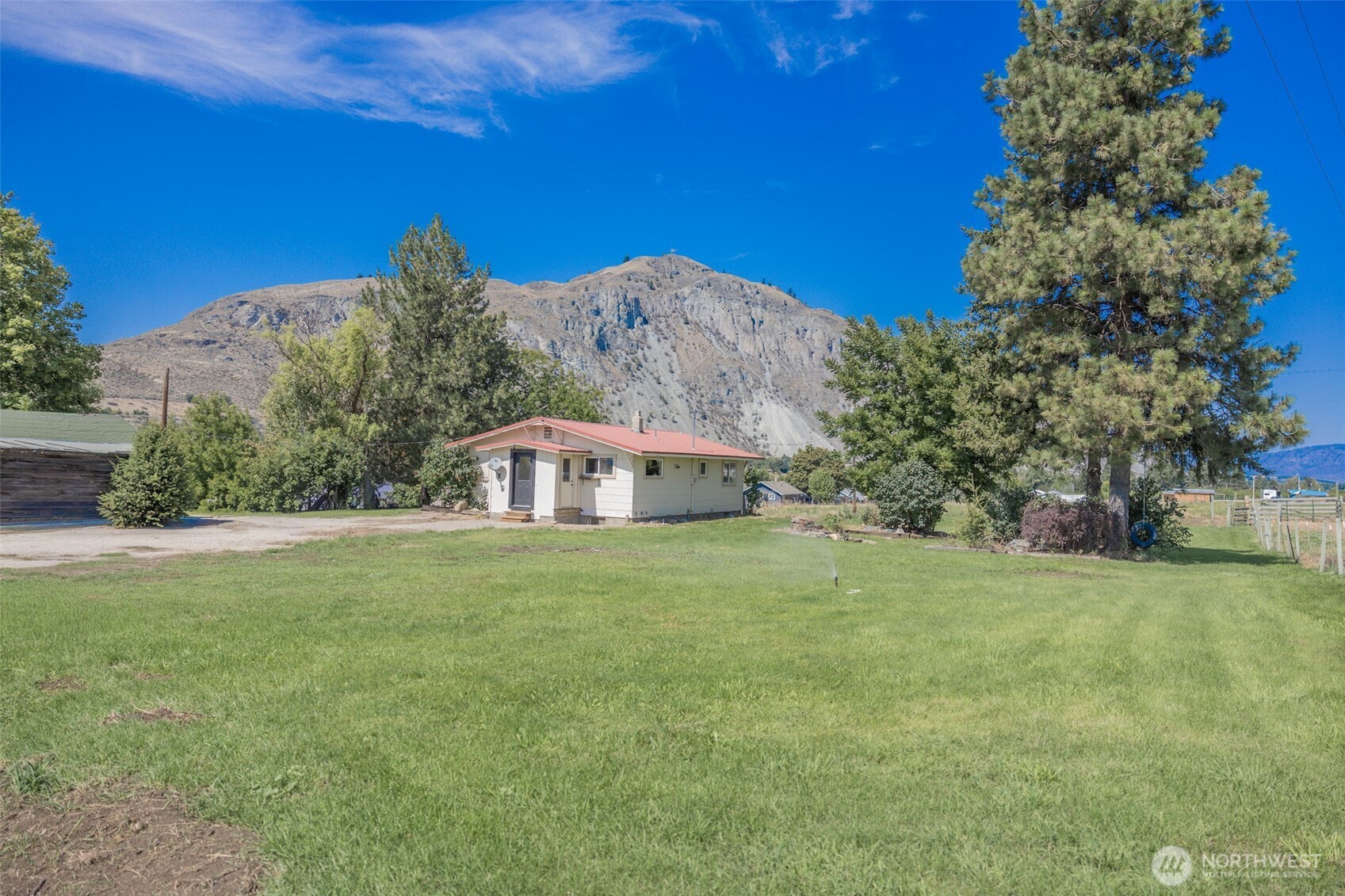 12 A Temby Road Tonasket, WA 98855 - Photo 29 of 36 a view of a trees in a yard with a house in the background