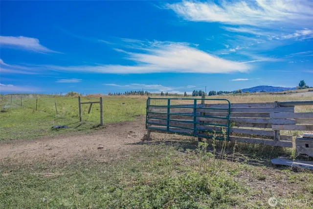 a view of a yard with wooden fence
