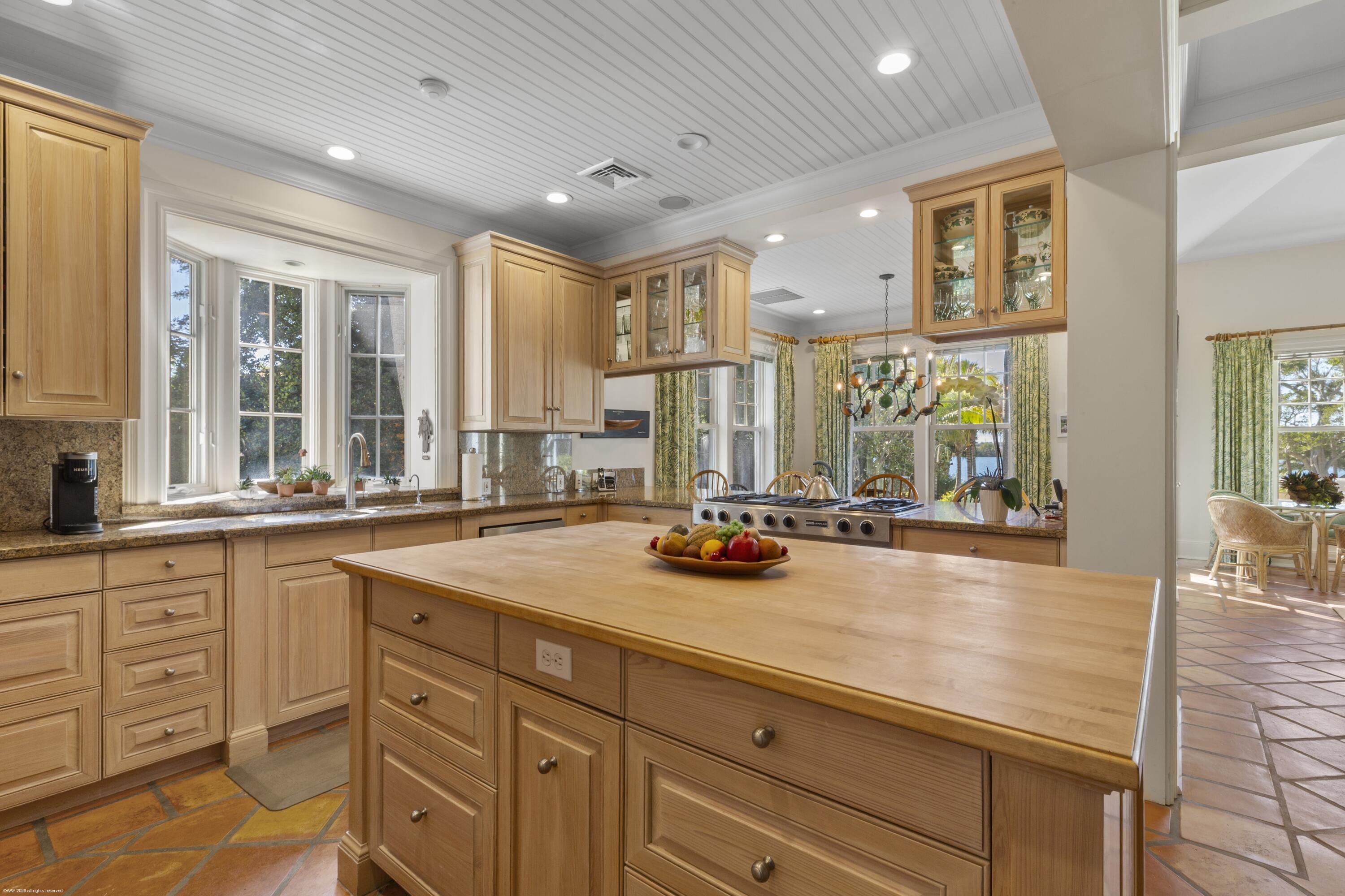 228 South Beach Road Jupiter Island, FL 33455 - Photo 16 of 40 a view of a kitchen counter top space with wooden floor and staircase