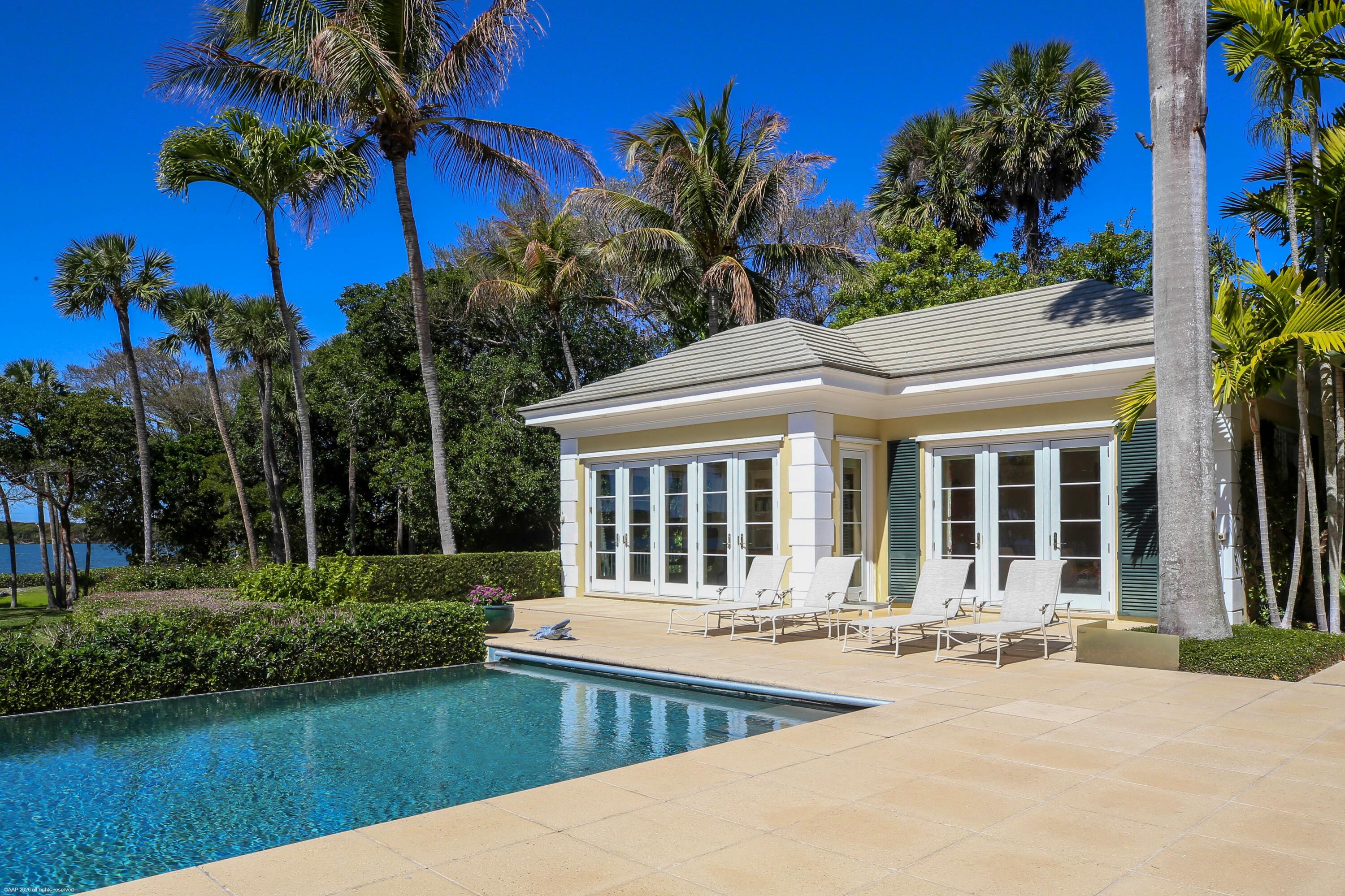 228 South Beach Road Jupiter Island, FL 33455 - Photo 32 of 40 a front view of a house with garden and patio