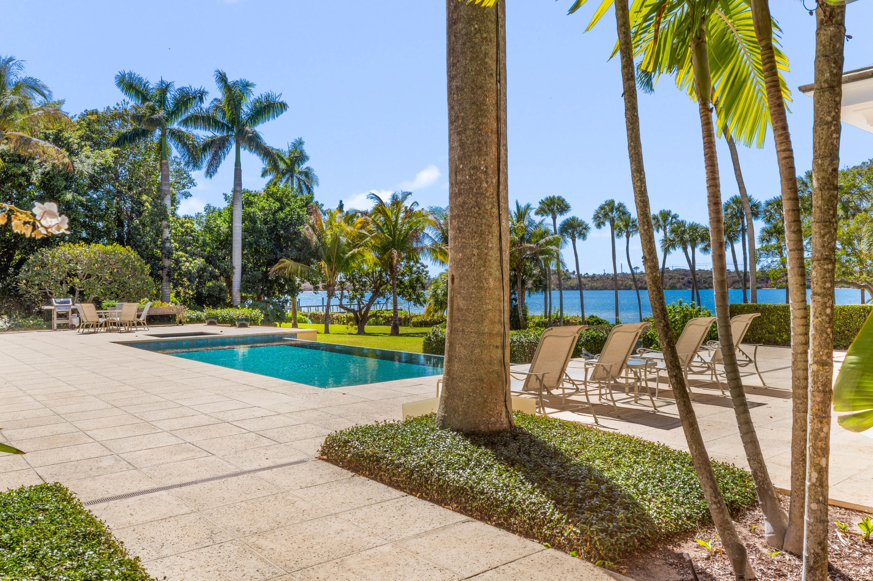228 South Beach Road Jupiter Island, FL 33455 - Photo 4 of 40 a view of a swimming pool with a patio