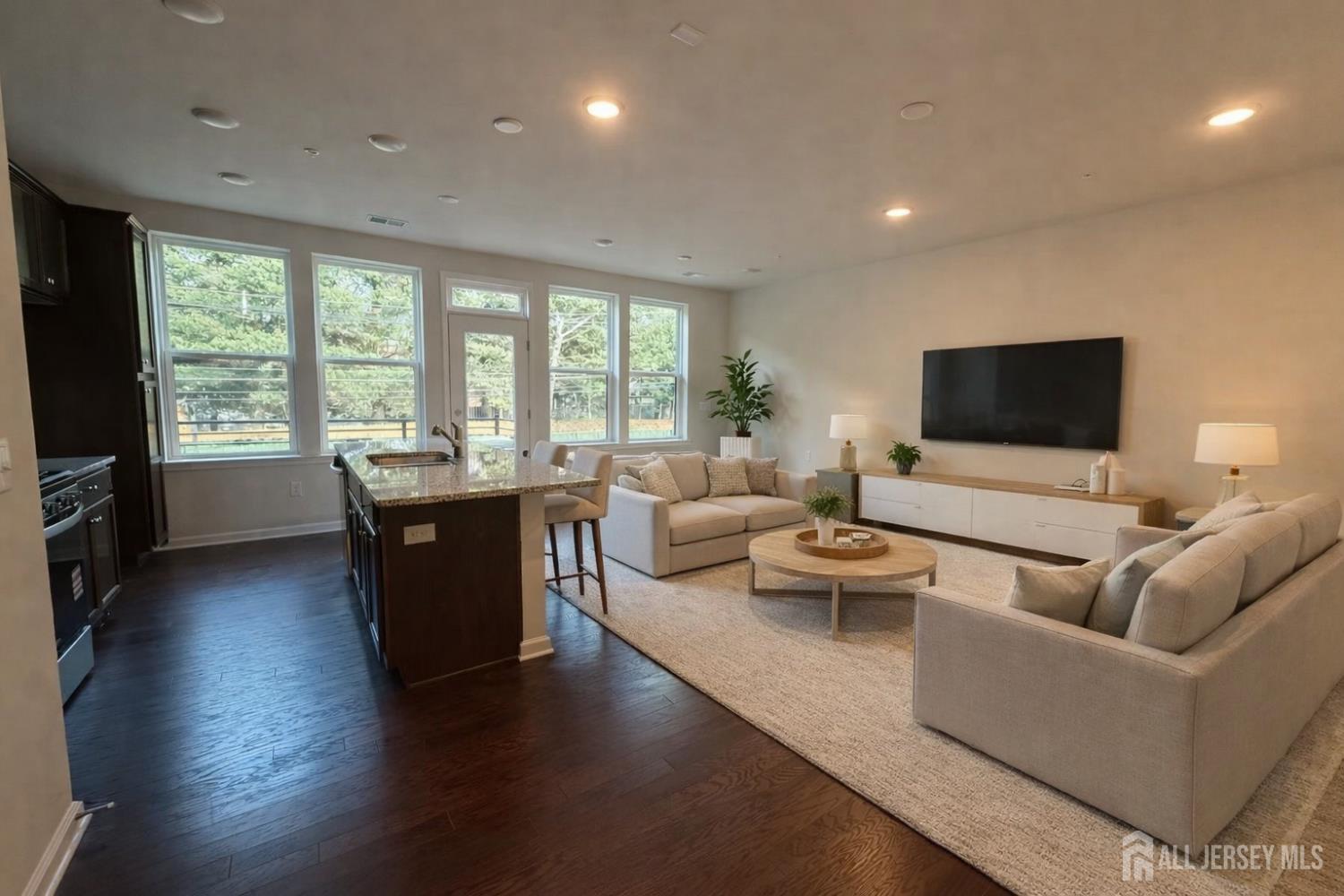 a living room with furniture a flat screen tv and a large window