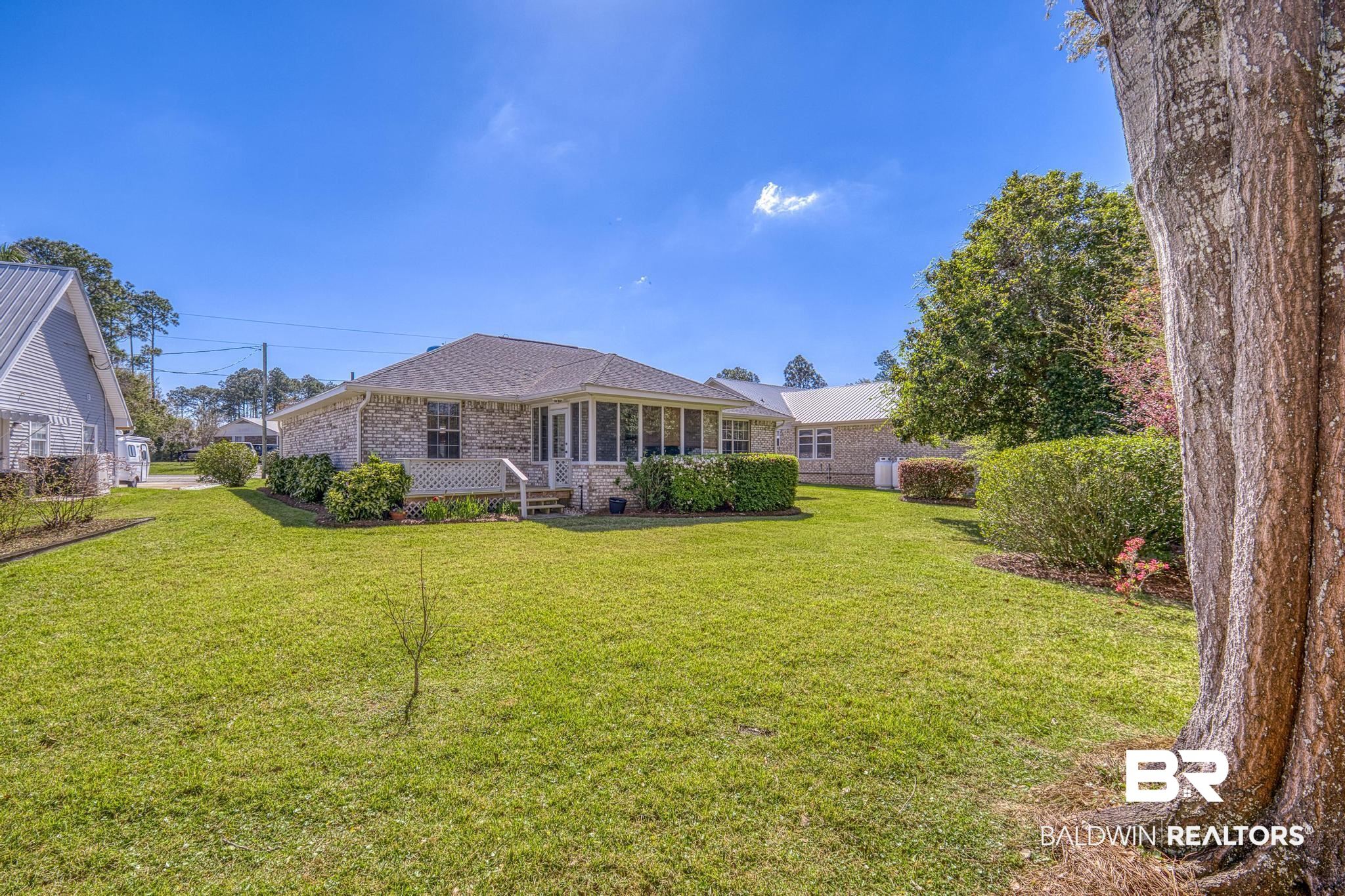 2881 Eslava Circle Lillian, AL 36549 - Photo 31 of 58 Back of property featuring brick siding, a lawn, and a porch