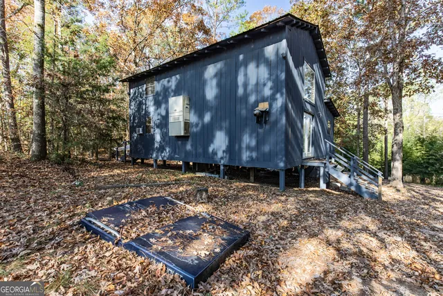 a view of a backyard with a large tree and wooden fence