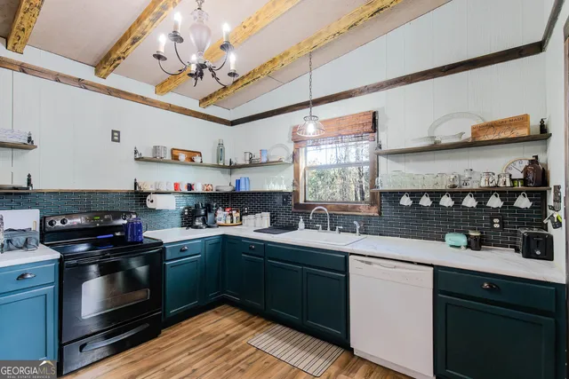 a kitchen with stainless steel appliances granite countertop a sink a stove and cabinets