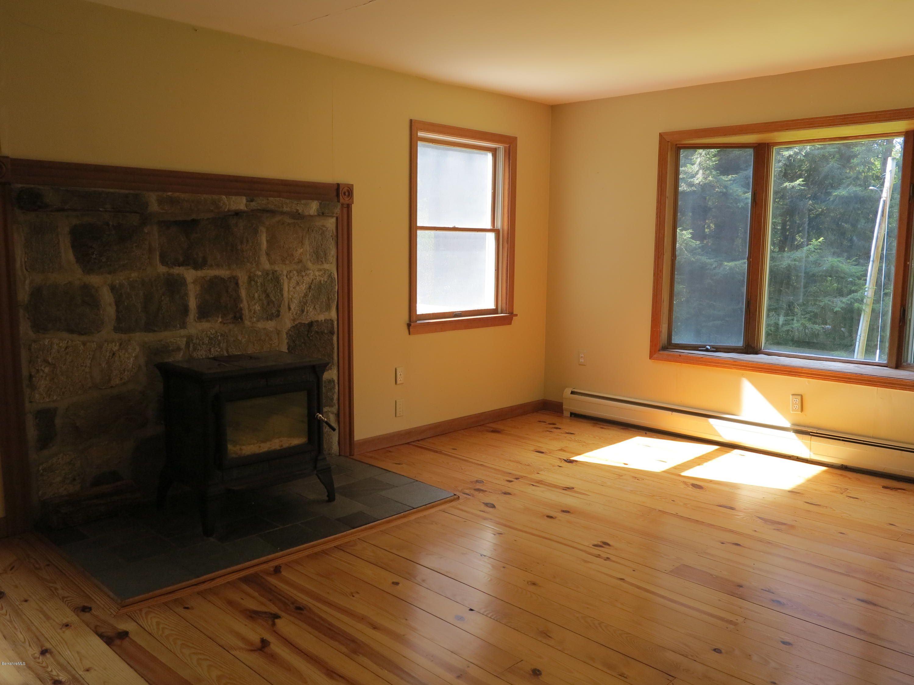98 Tyringham Road Otis, MA 01253 - Photo 4 of 17 a view of an empty room with wooden floor and a window