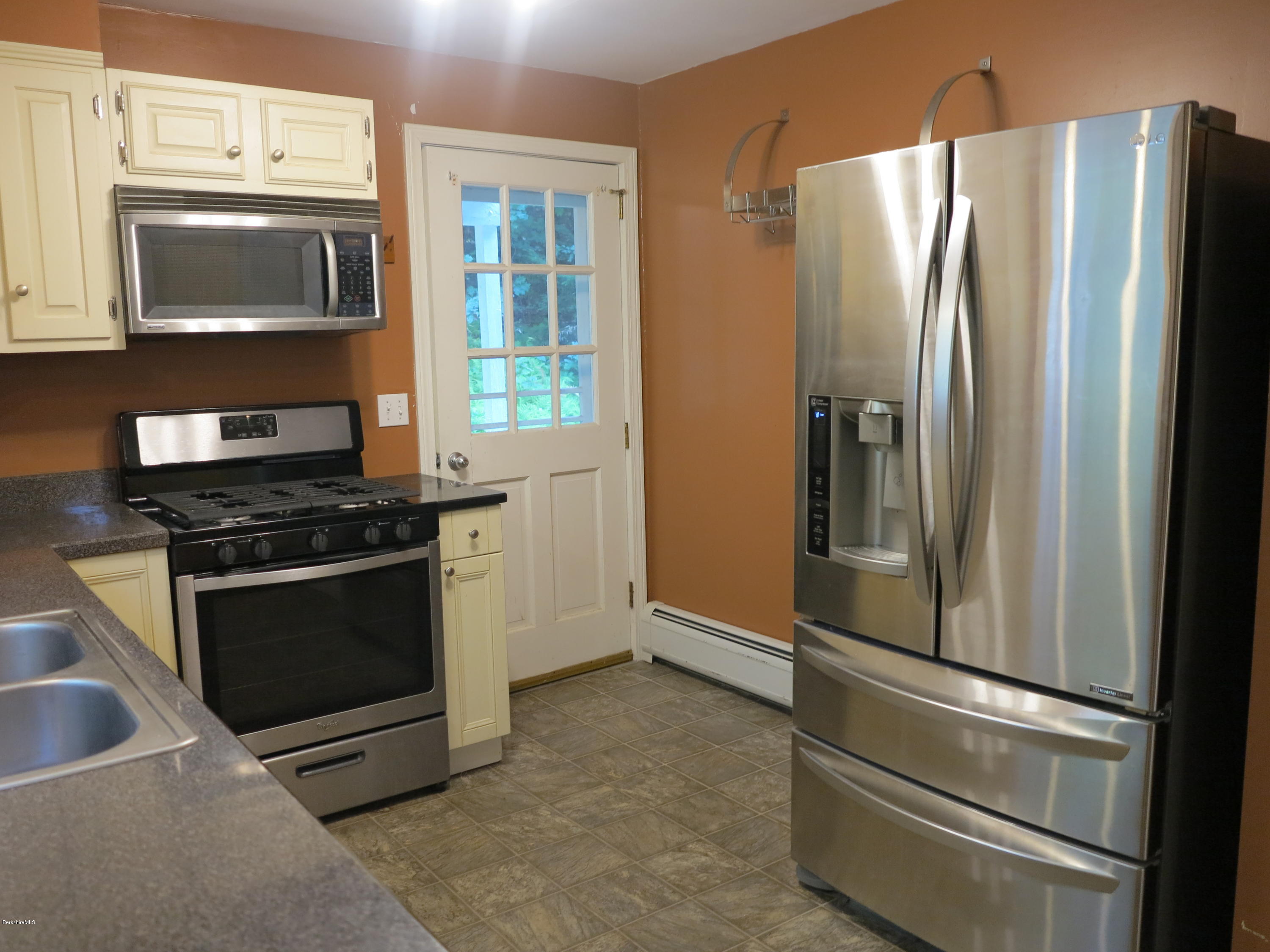 98 Tyringham Road Otis, MA 01253 - Photo 7 of 17 a kitchen with granite countertop a refrigerator and a stove top oven