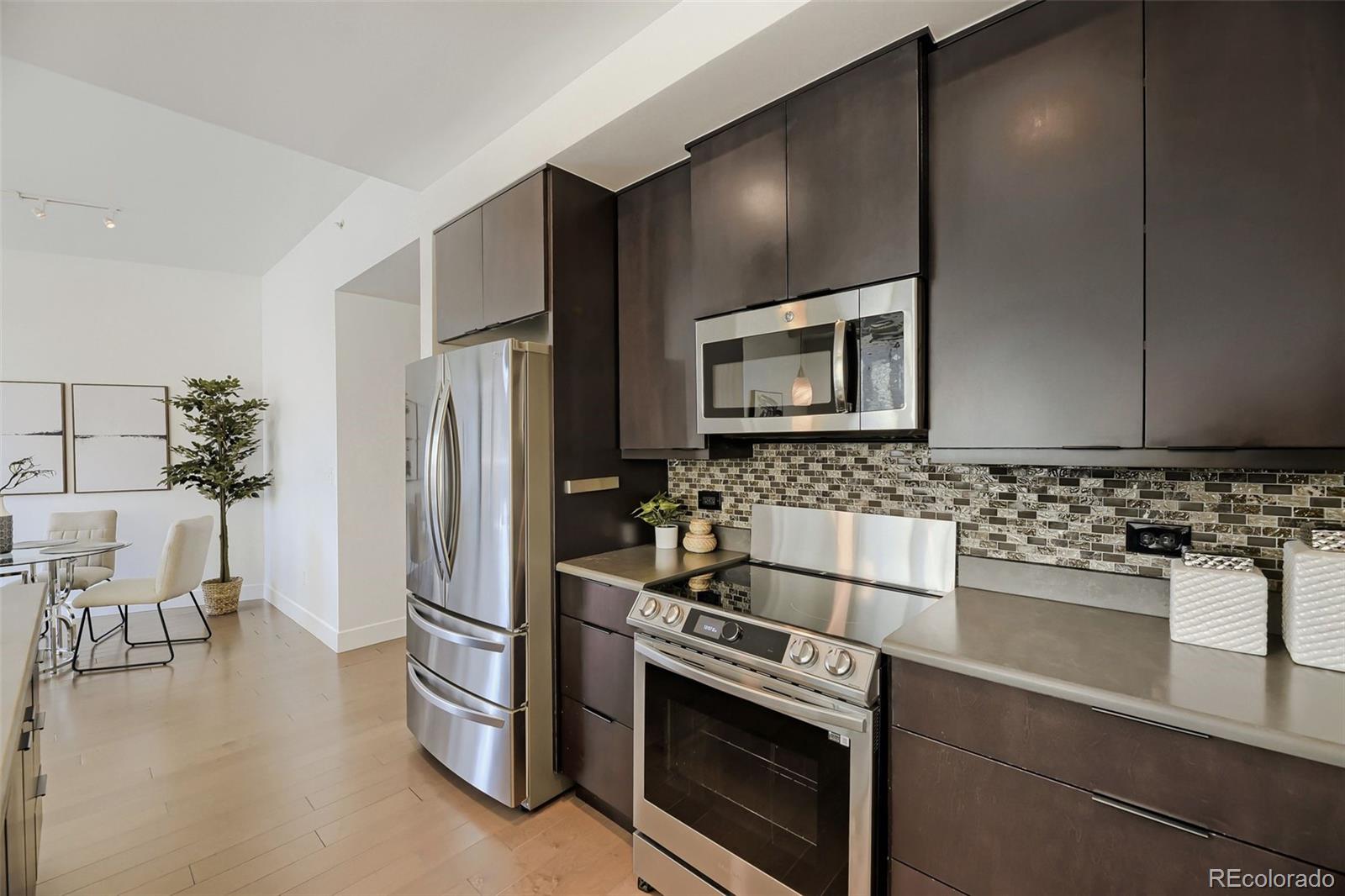 2001 Lincoln Street, Unit 710 Denver, CO 80202 - Photo 11 of 27 a kitchen with stainless steel appliances a refrigerator sink and microwave