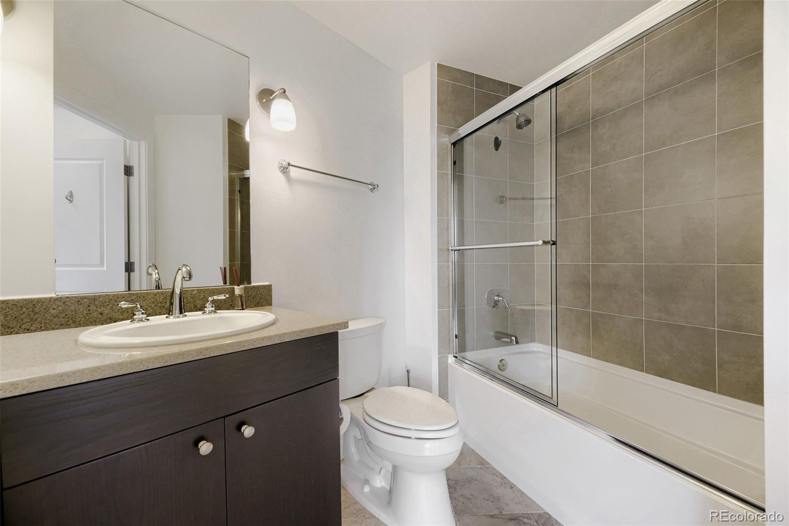 2001 Lincoln Street, Unit 710 Denver, CO 80202 - Photo 8 of 27 a bathroom with a bathtub shower sink mirror and toilet