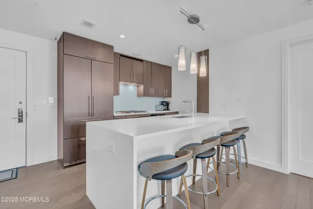 a kitchen with kitchen island a stove a table and chairs in it