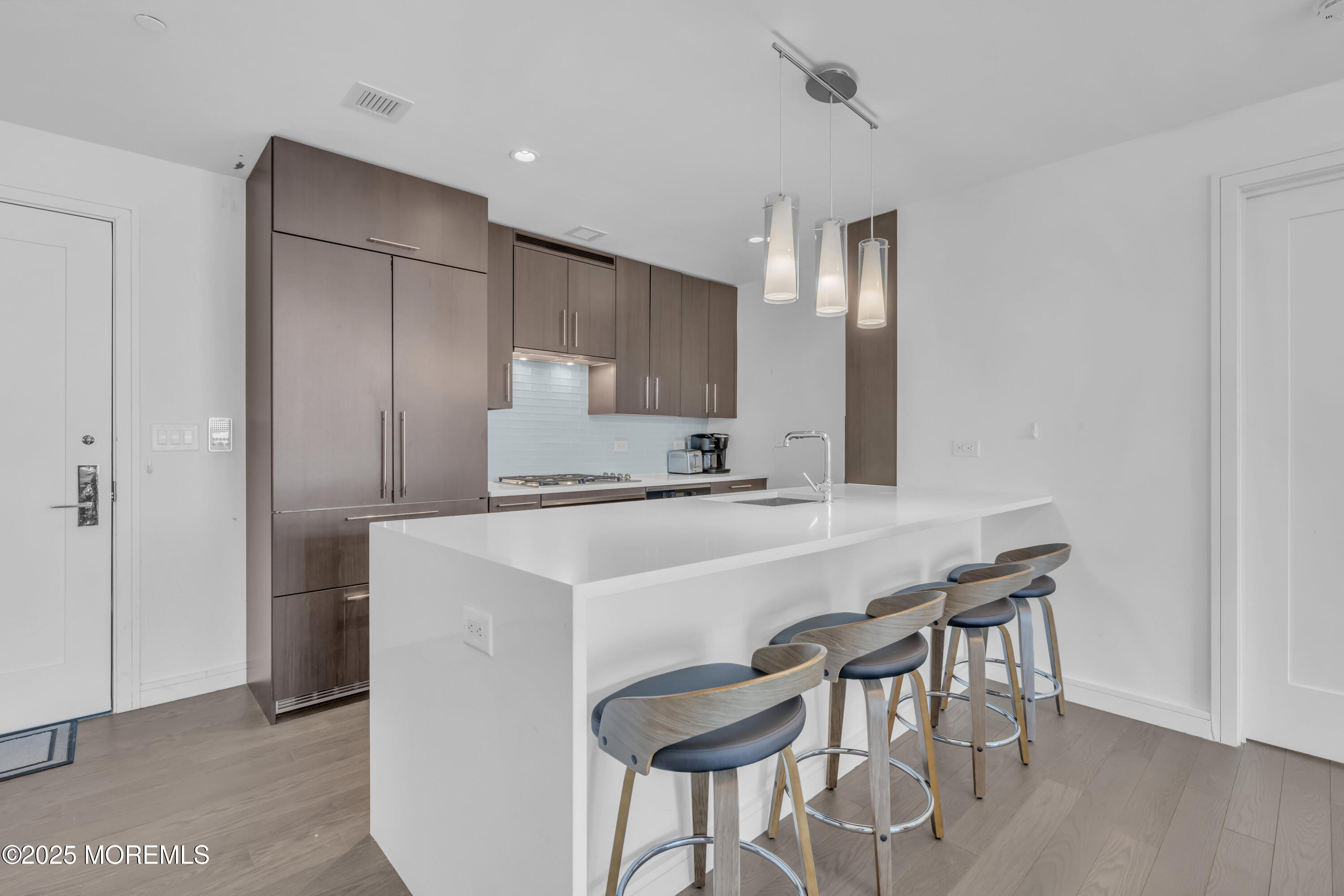 20 Melrose Terrace, Unit 509 Long Branch, NJ 07740 - Photo 5 of 24 a kitchen with kitchen island a stove a table and chairs in it